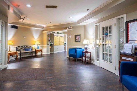 A waiting room with a blue chair and a couch.