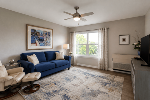 A living room with a blue couch and a fan.