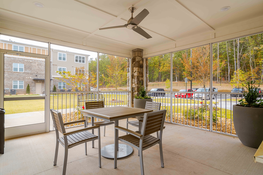 A patio with a table and chairs and a ceiling fan at Sweetwater Point in Douglasville, GA