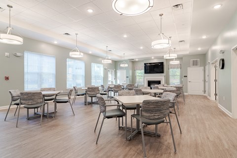 a large dining room with tables and chairs and a fireplace at Sweetwater Point in Douglasville, GA