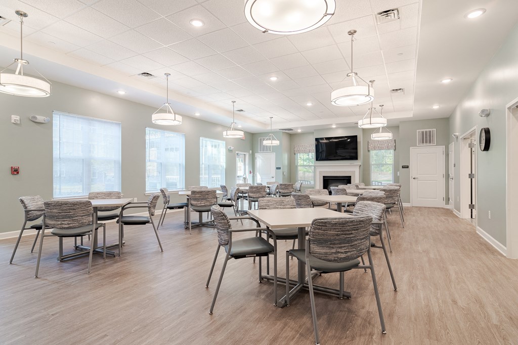 a large dining room with tables and chairs and a fireplace at Sweetwater Point in Douglasville, GA