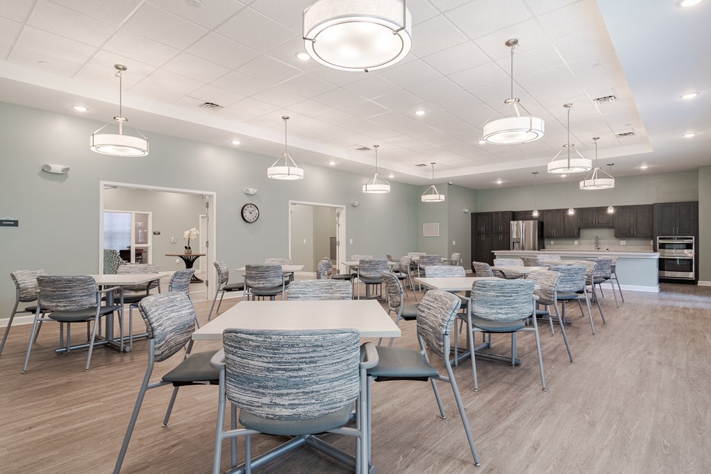 a large dining room with tables and chairs and a kitchen at Sweetwater Point in Douglasville, GA