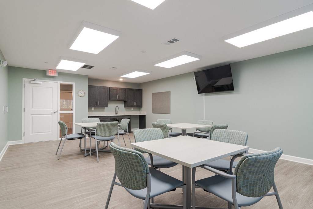 Craft room with tables, chairs, and TV at Sweetwater Point in Douglasville, GA
