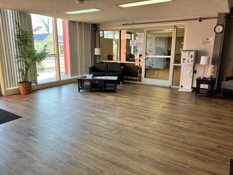A room with wooden flooring and a black couch.