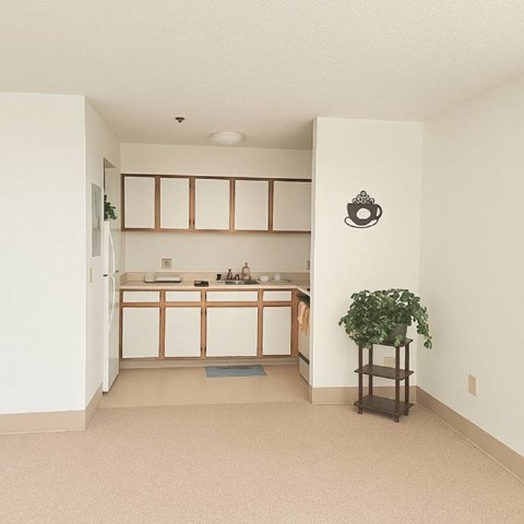 A kitchen with white cabinets and a sink.