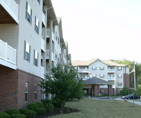 A large apartment complex with a brick building and a white building with balconies.