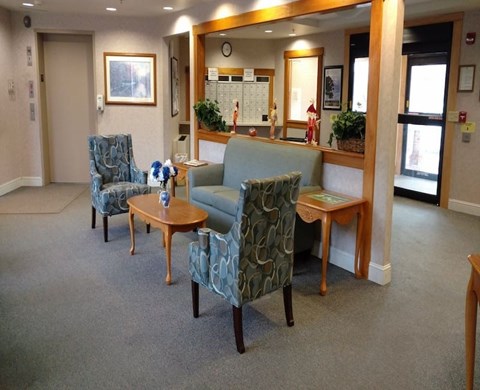 A waiting room with two chairs and a sofa.