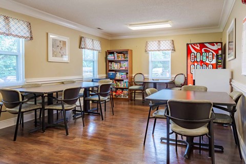 A dining room with a table surrounded by chairs.