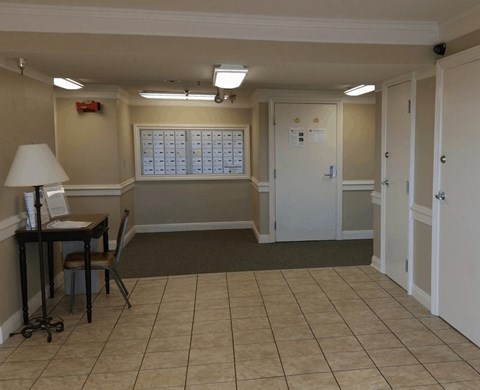 A room with a desk, chair, and a calendar on the wall.