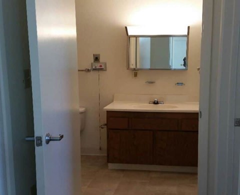 A bathroom with a sink, mirror, and toilet.