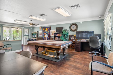 A room with a table, chairs, and a fan.
