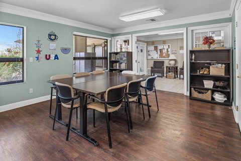 A dining room with a table and chairs.