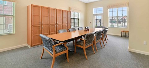 Conference room with large table and upholstered chairs at Avondale Senior Village Apartments, Dublin, Ohio