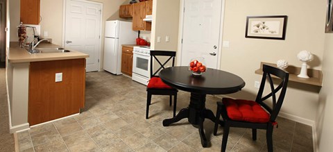 A kitchen with a table and chairs in the middle of the room.