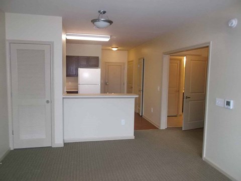 A kitchen area with a white refrigerator and a counter.
