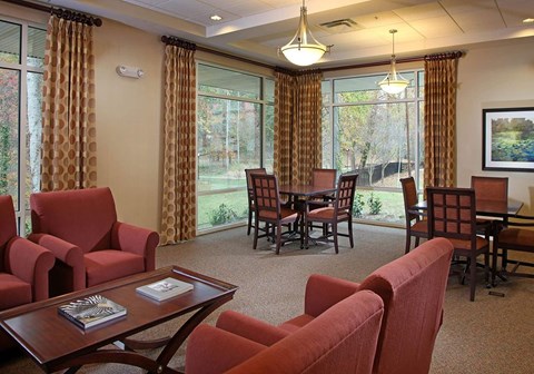 A living room with red chairs and a wooden coffee table.