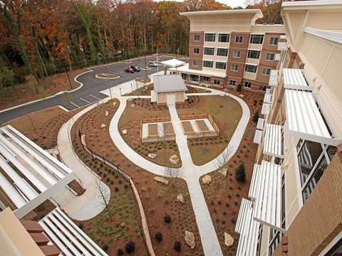 A courtyard surrounded by buildings with a white fence.