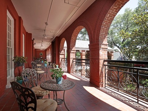 A balcony with a table and chairs.