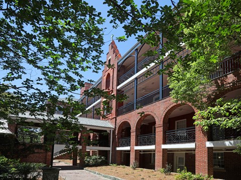 A red brick building with a tower and balconies.