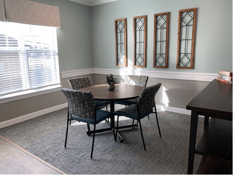 A dining room with a table and chairs.