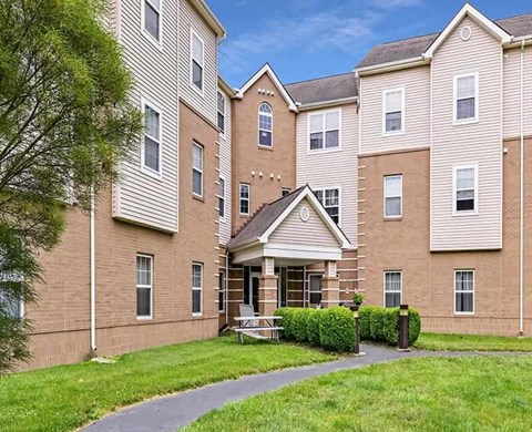 A large apartment complex with a grassy courtyard in front.