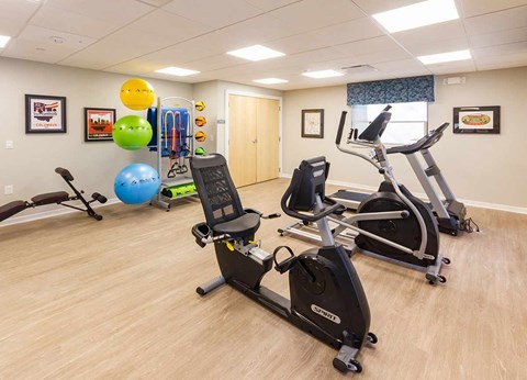 A gym room with exercise equipment and a blue exercise ball.