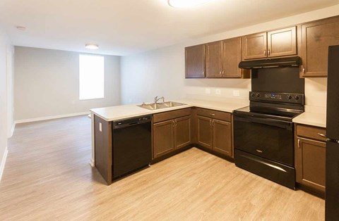 A kitchen with wooden cabinets and a black oven.