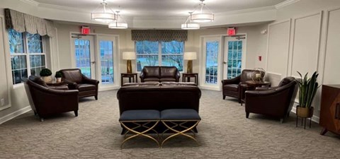A living room with brown furniture and a carpet.