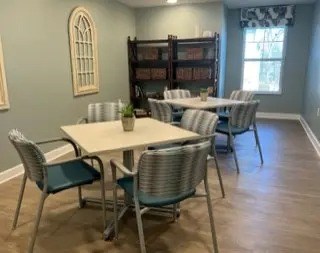 A dining room with a table and chairs.