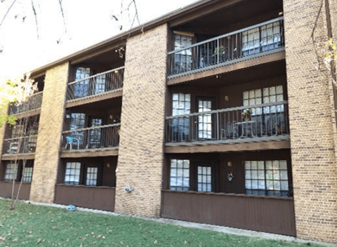 A brown building with a balcony on the second floor.
