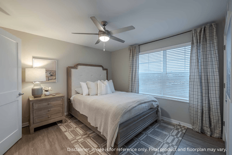 A bedroom with a bed, nightstand, and window.
