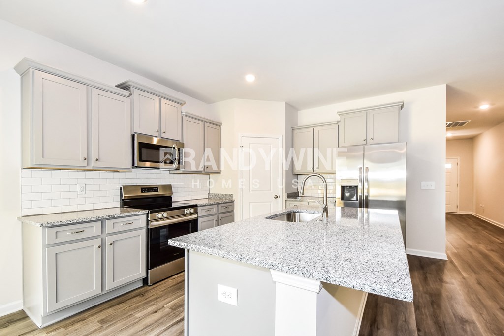 a kitchen with a marble counter top and white cabinets