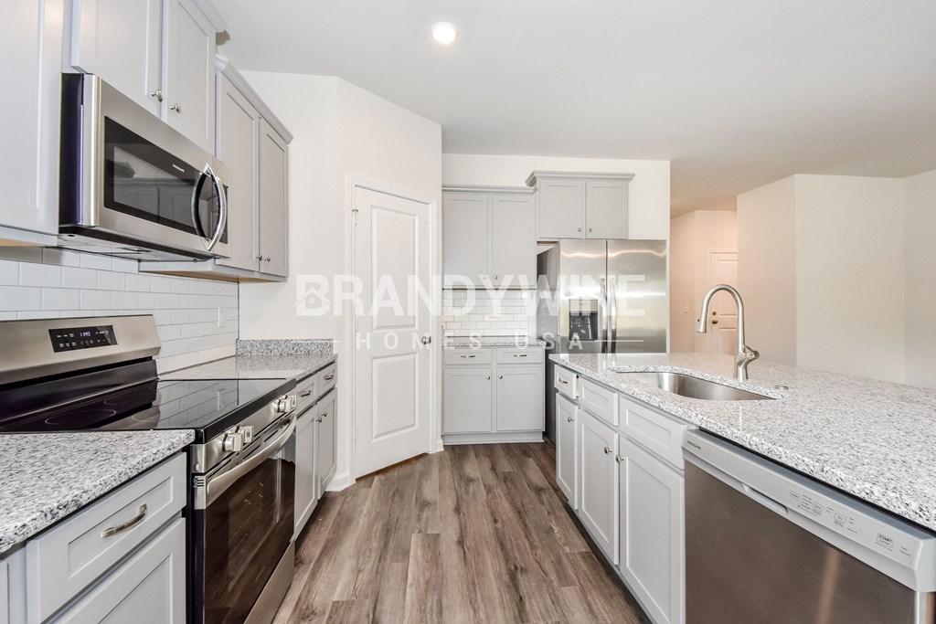 a kitchen with marble counter tops and white cabinets