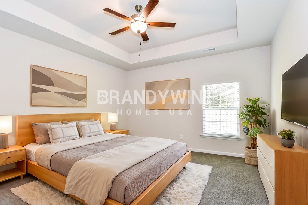 a bedroom with a bed and a ceiling fan and a tv