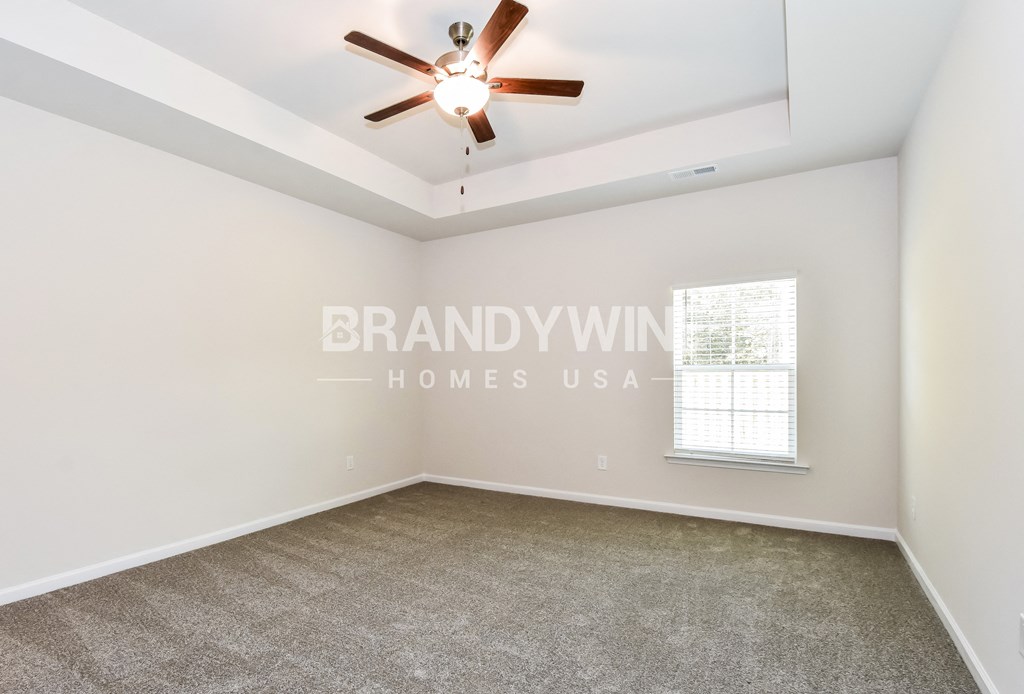 a living room with carpet and a ceiling fan