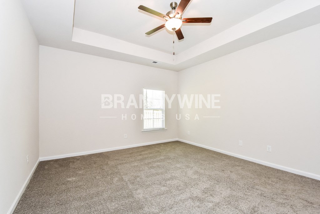 a living room with carpet and a ceiling fan