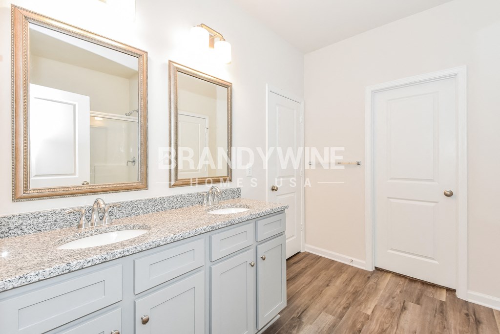 renovated bathroom of a home with white cabinets and granite counter tops