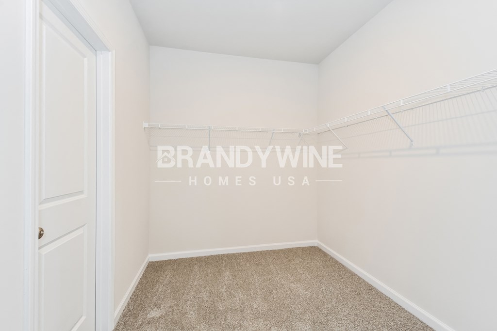 a bedroom with white walls and carpet and a closet