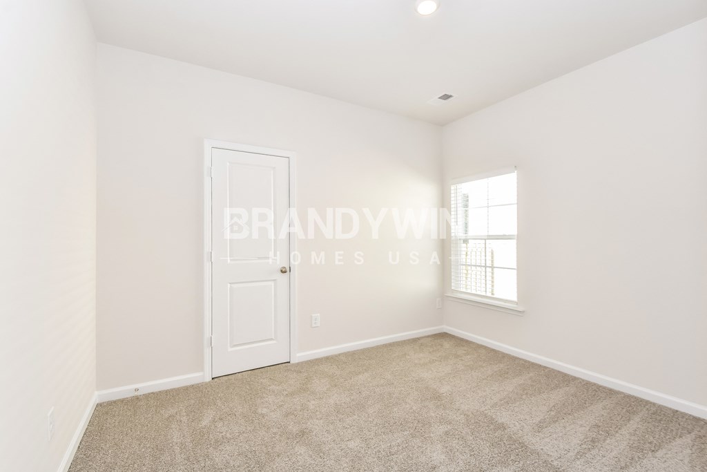 a bedroom with carpeting and a white door