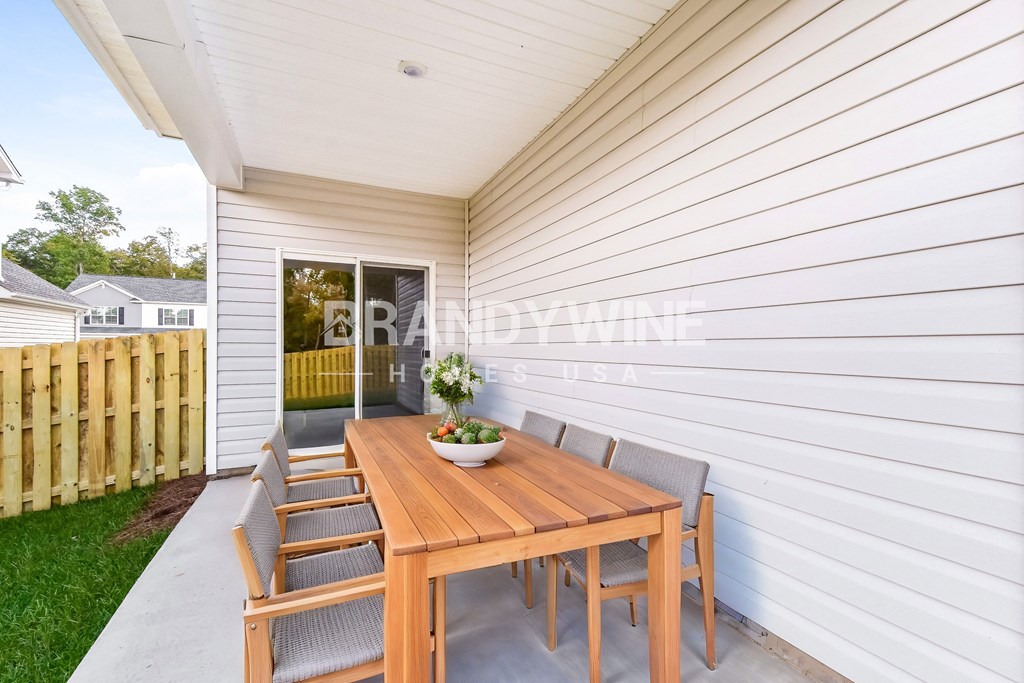 a backyard patio with a wooden table and chairs