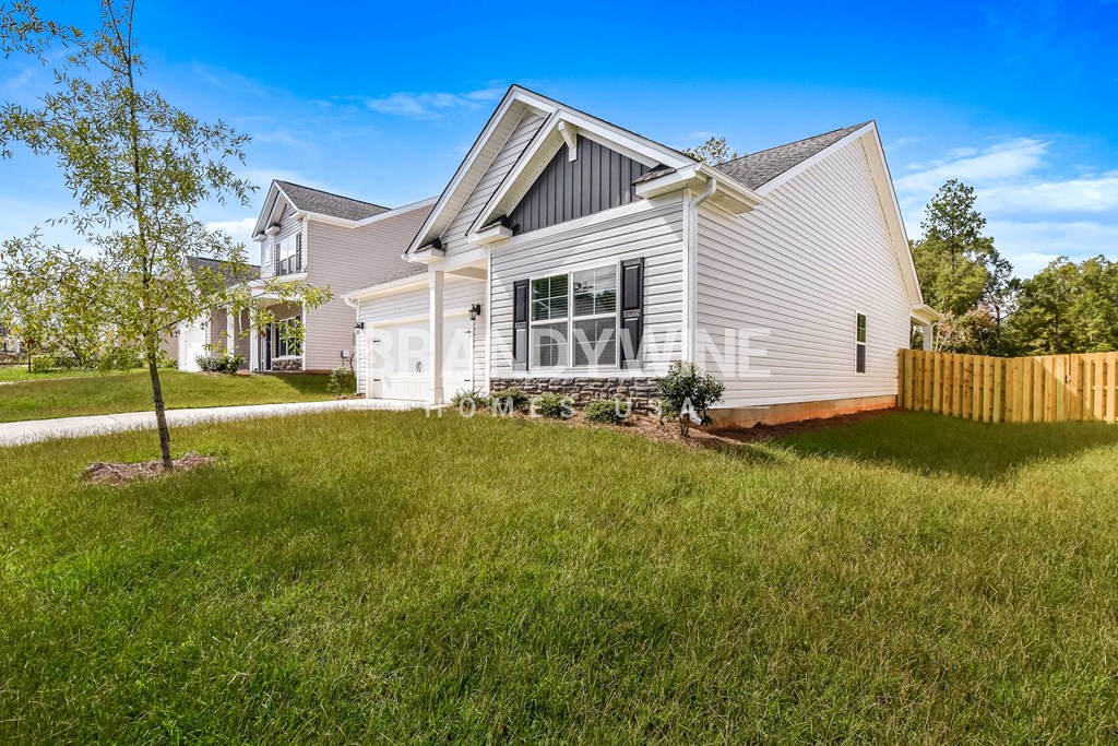 a white house with a yard and a wooden fence
