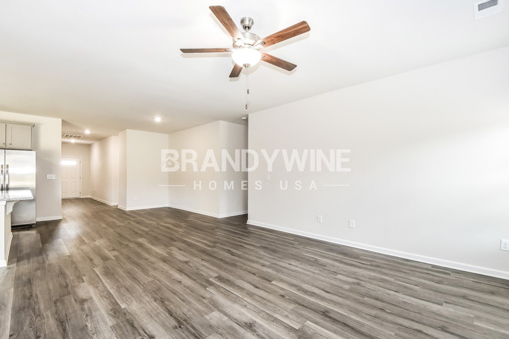 a living room with hardwood floors and a ceiling fan