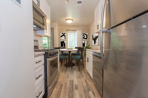 a kitchen with stainless steel appliances and a table with chairs