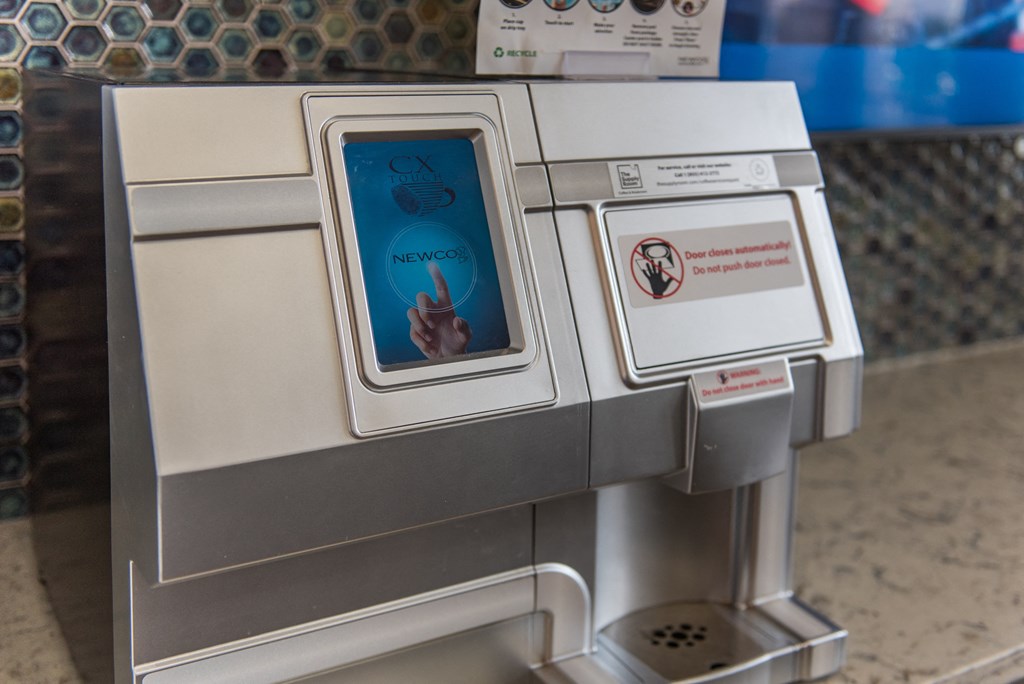 an atm machine with a screen showing a hand pressing a button at The Whitworth, Williamsburg, 23185