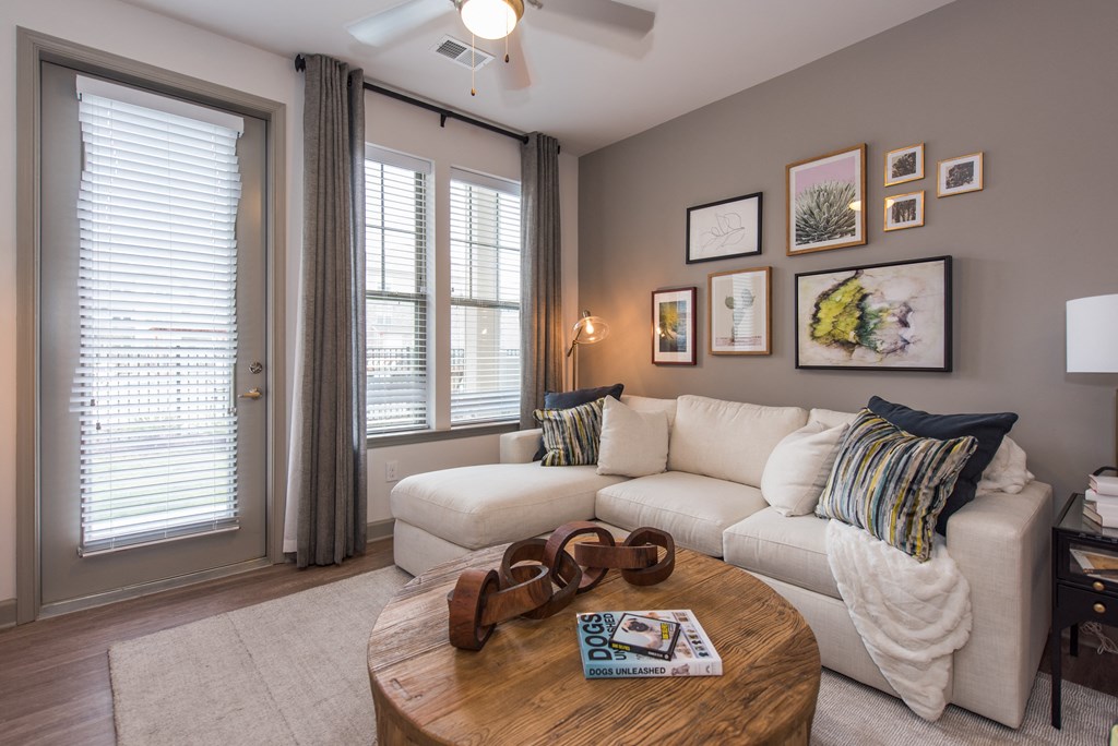 a living room with a white couch and a coffee table with a pair of brown suede at The Whitworth, Williamsburg, VA