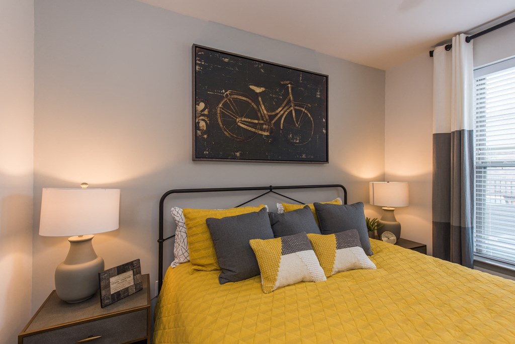 a bedroom with a yellow bedspread and grey and yellow pillows at The Whitworth, Virginia