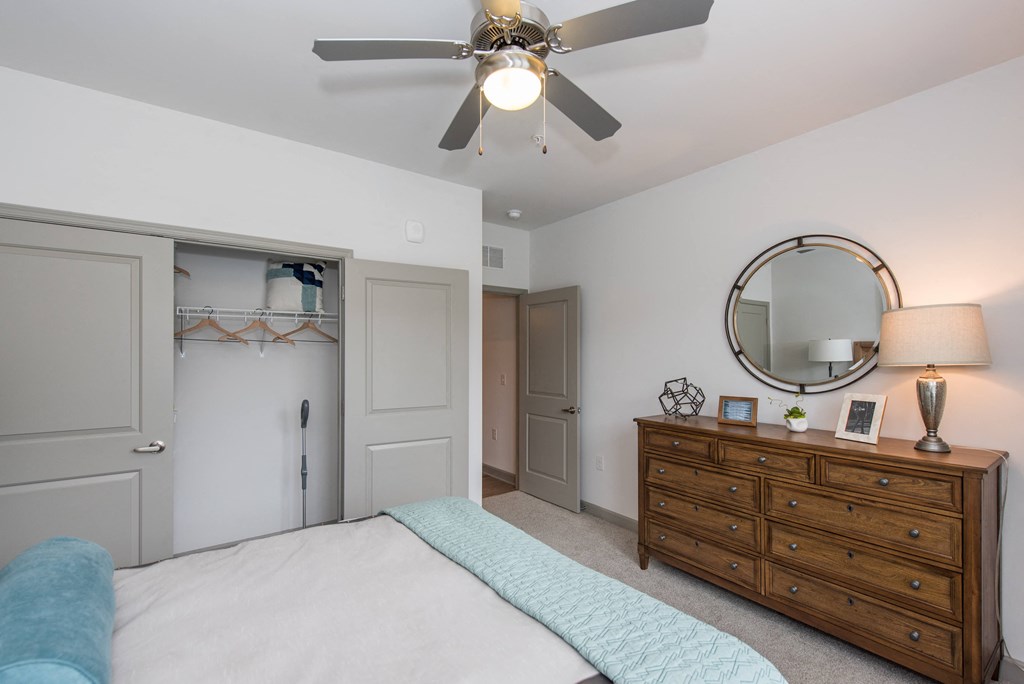 a bedroom with a bed and a dresser with a mirror at The Whitworth, Williamsburg, Virginia