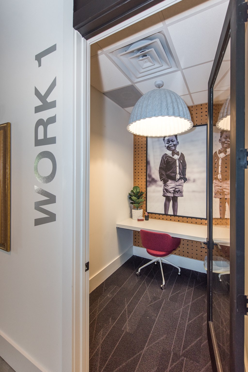 a room with a desk and a lamp and a picture on the wall