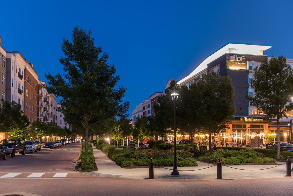 a city street at night with buildings and trees