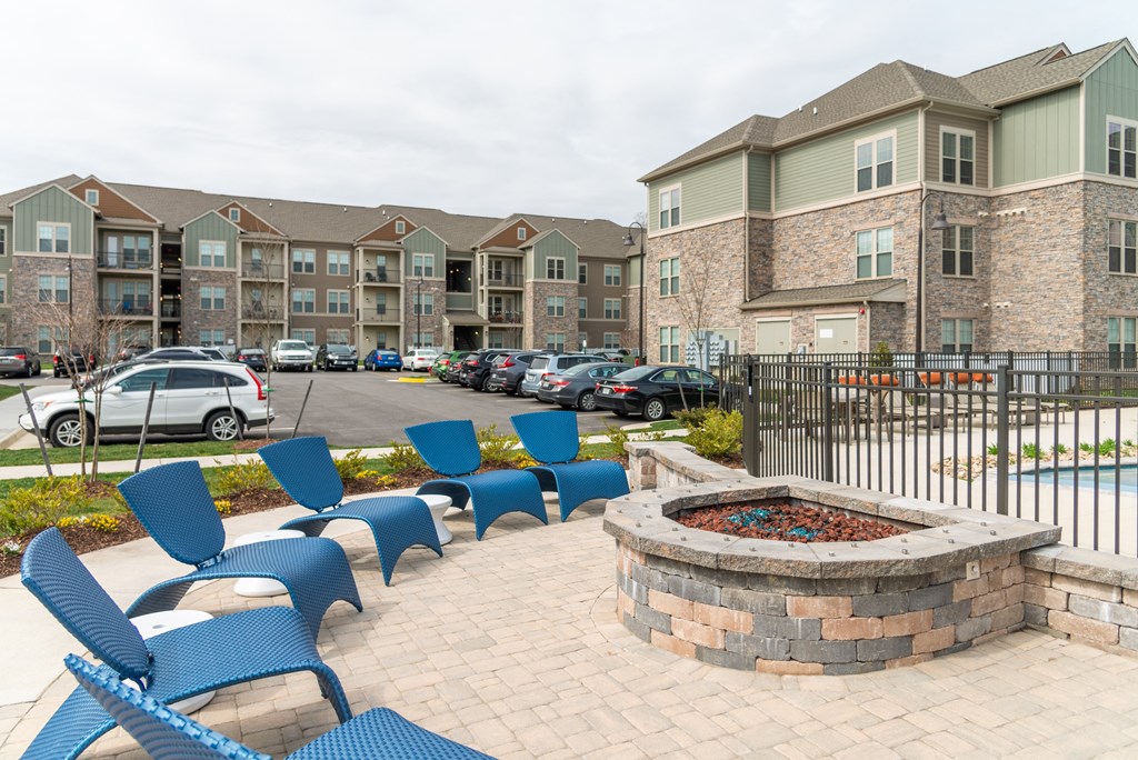 a firepit and lounge chairs sit in front of an apartment complex at The Whitworth, Virginia